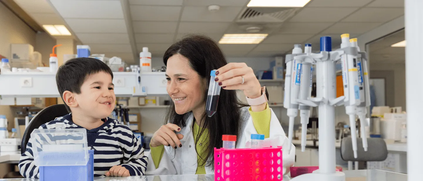 Un garçon en visite dans le laboratoire Généthon en compagnie d'une chercheuse