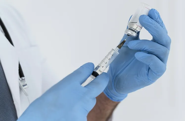 Vignette Actualité - Docteur tenant une seringue et un produit d'injection dans ses mains