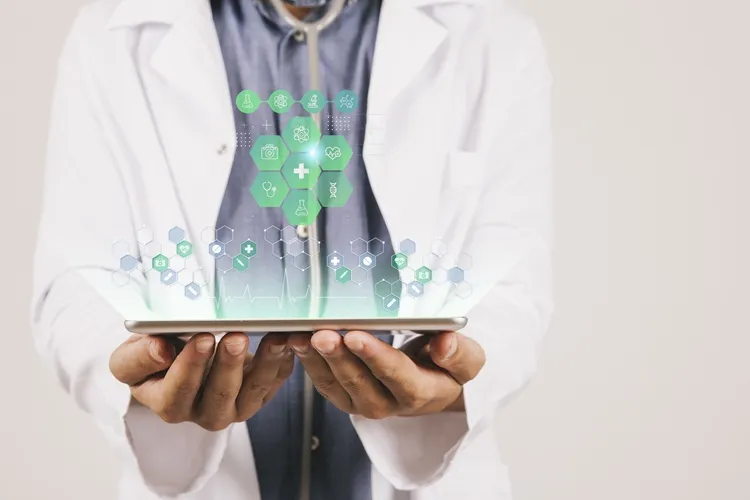 Vignette Actualité : Un professionnel de santé en blouse blanche tient une tablette affichant des icônes numériques liées à la médecine et à la recherche