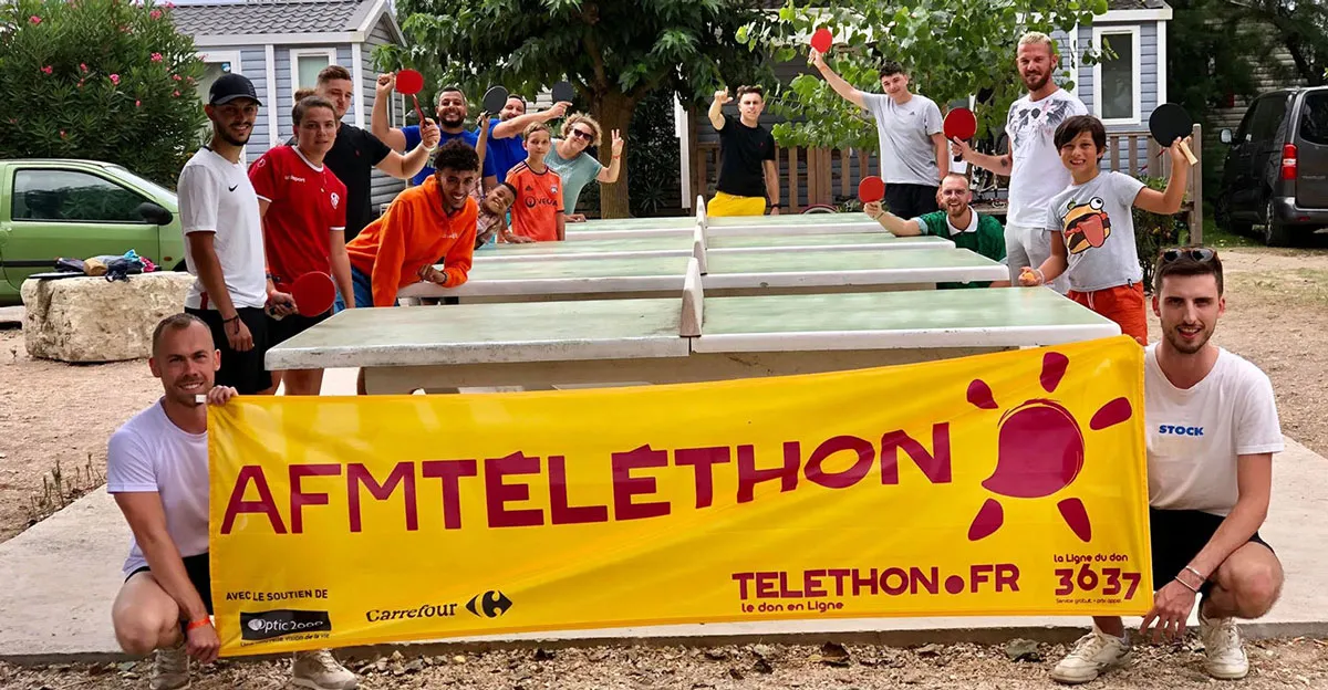 Des participants au téléthon camping tiennent une banderole téléthon
