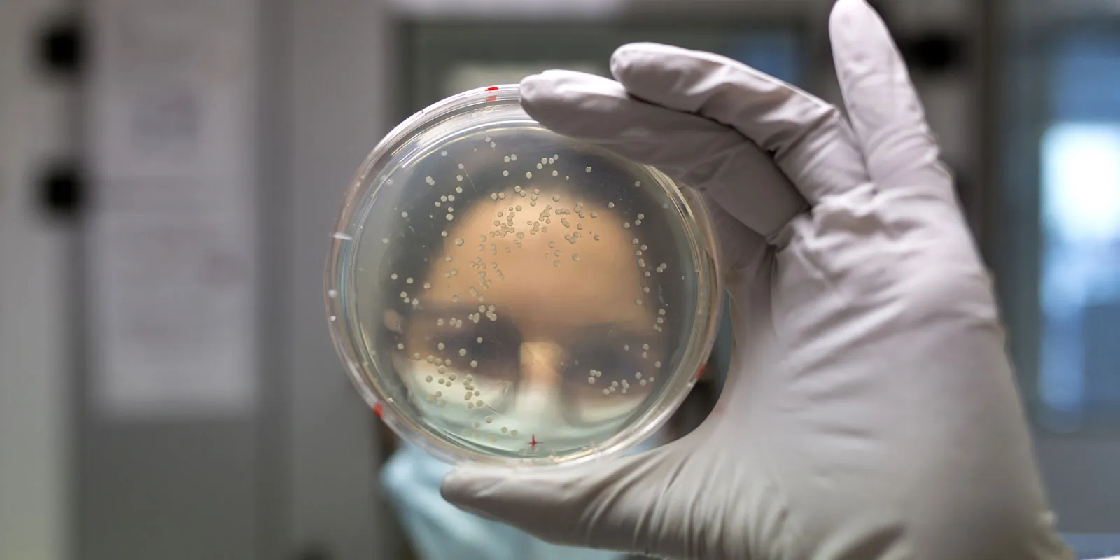 Une chercheuse de Généthon tient un flacon devant elle