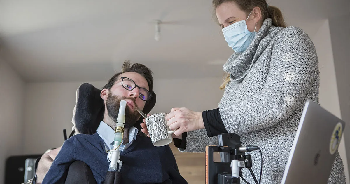Une femme aidant une personne en situation de handicap à domicile