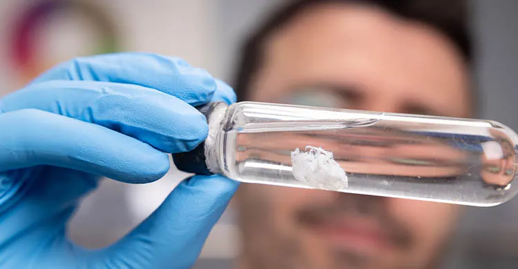 Une homme tenant un flacon de thérapie génique développé dans les laboratoires de l'AFM-Téléthon