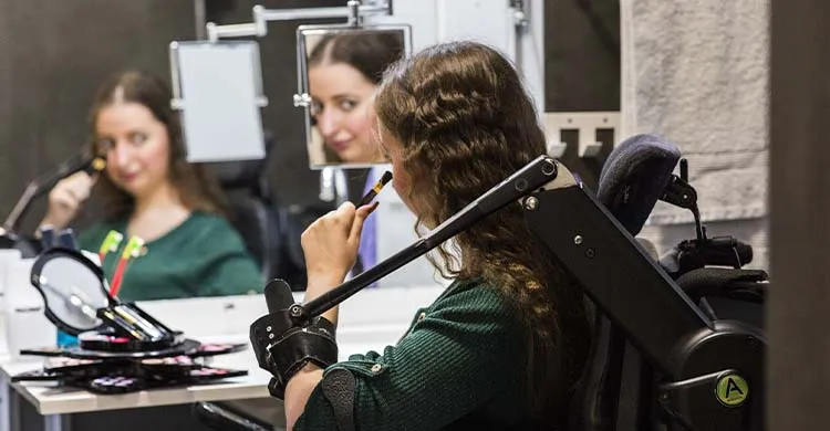 une jeune femme, équipée d'un support de bras, se maquille