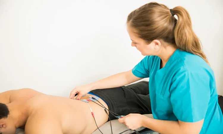 Vignette Actualité - Physiothérapeute positionnant les électrodes sur le patient pour le traitement des muscles du bas du dos en clinique