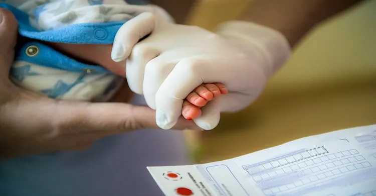 Vignette -  Un médecin qui effectue une analyse de sang chez un nouveau-né