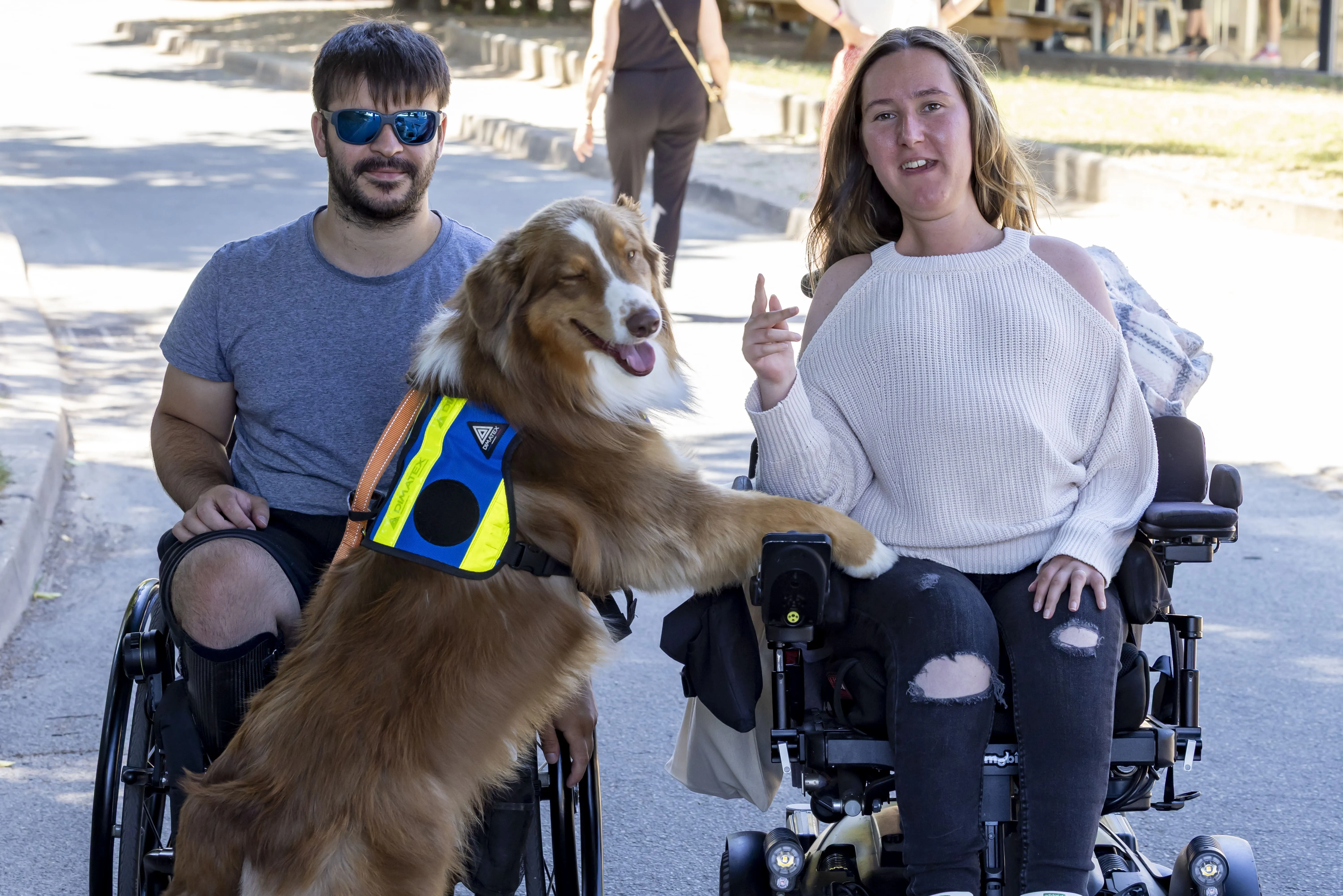 2 personnes en fauteuil accompagnées par un chien d'assistance