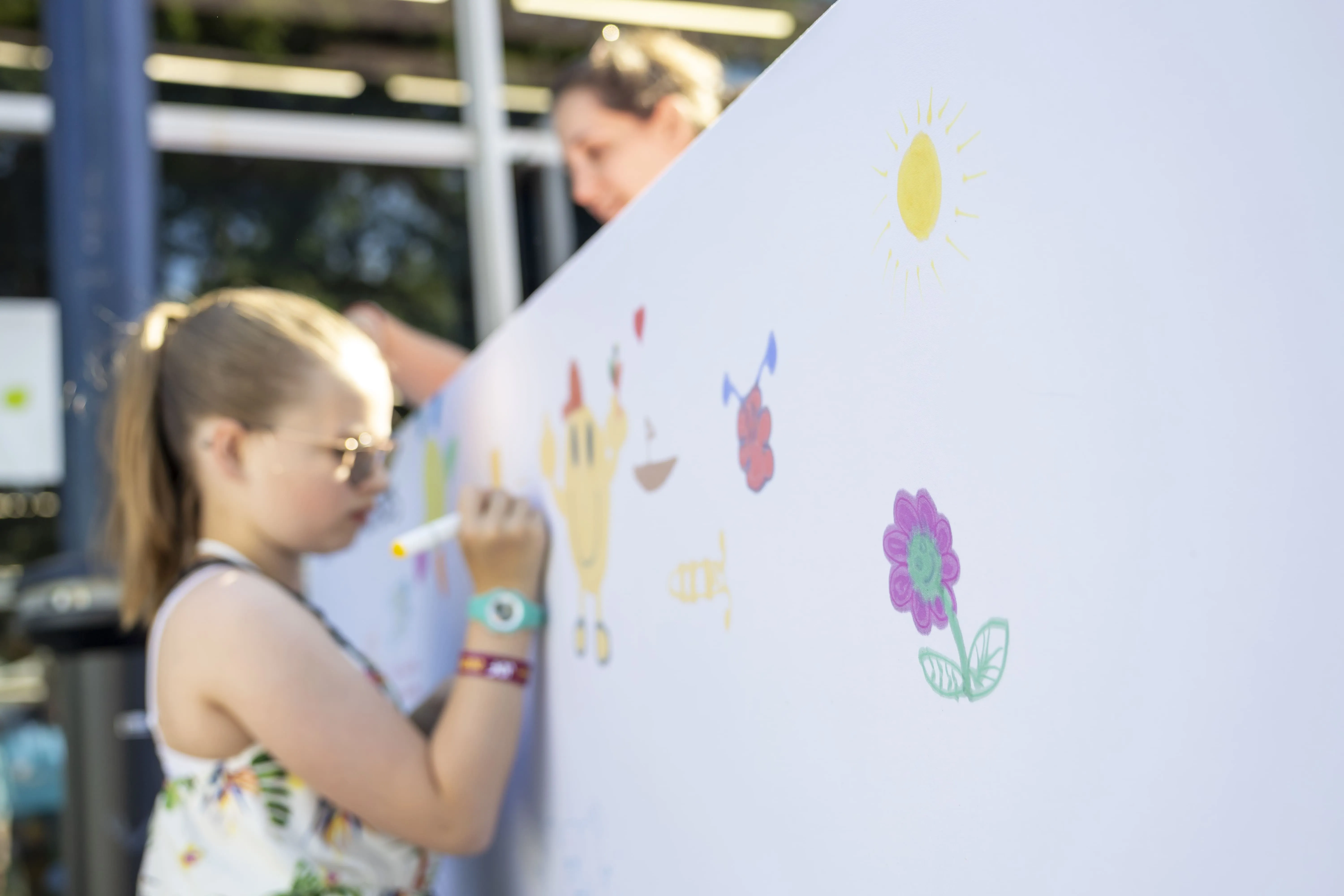 Une petite fille dessine sur un mur en soutien aux familles et au combat de l'AFM-Téléthon