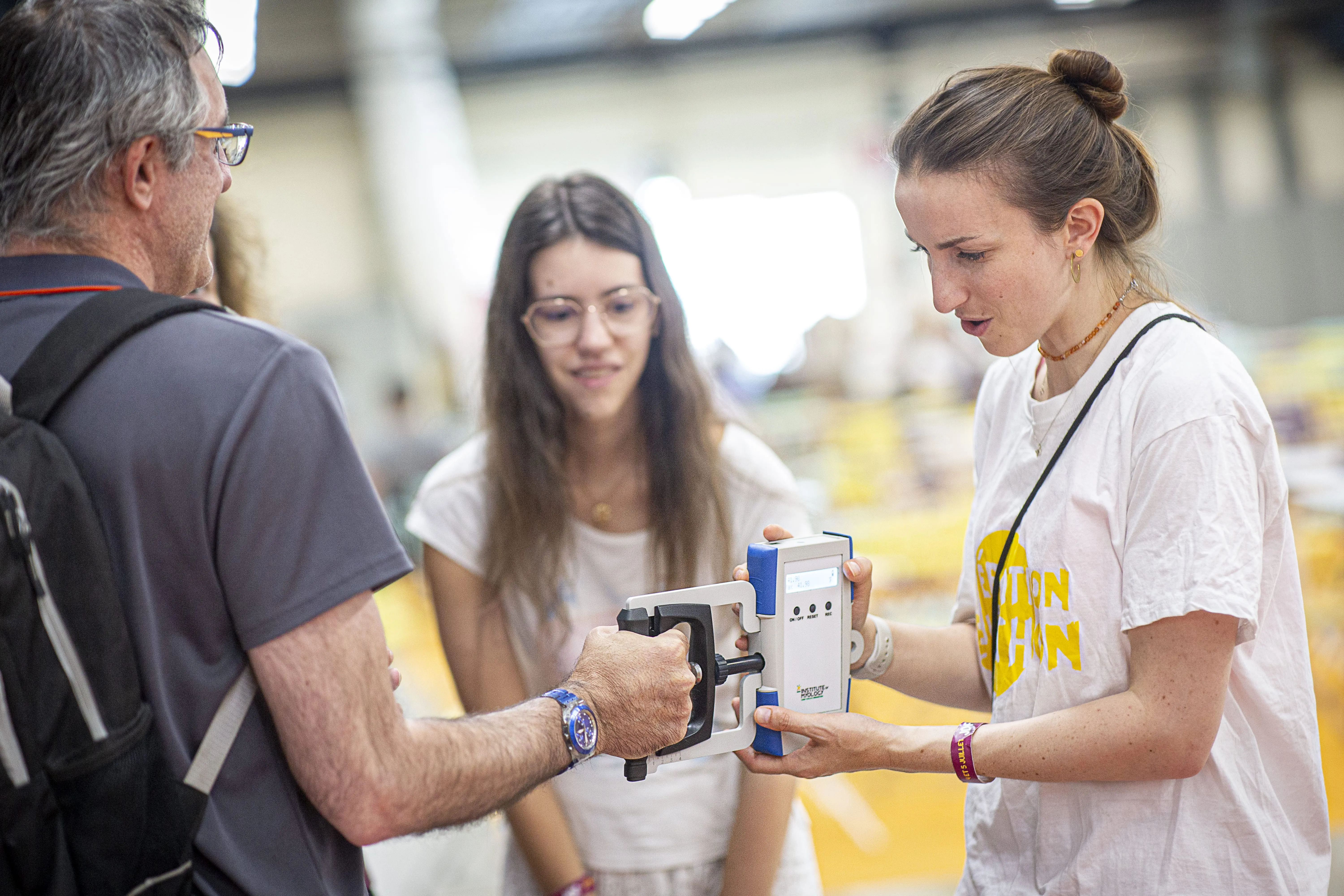 Un homme teste sa force avec les myotools sur le stand Café des chercheurs