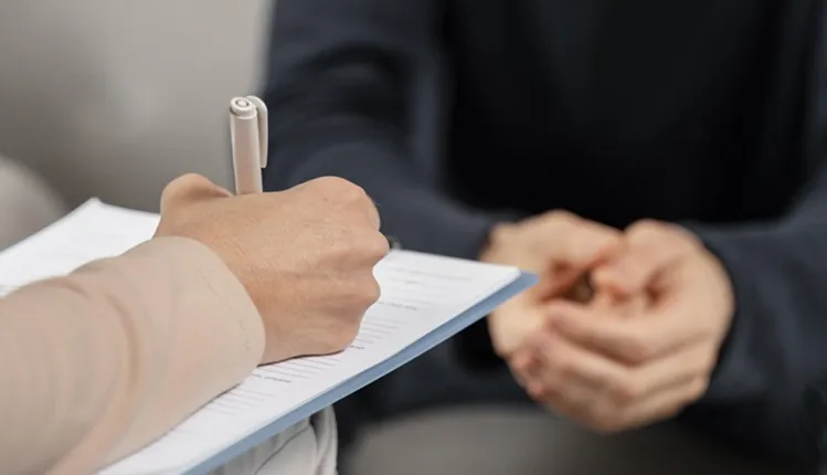 Vignette Actualité - Thérapeute qui prend des notes pendant une consultation