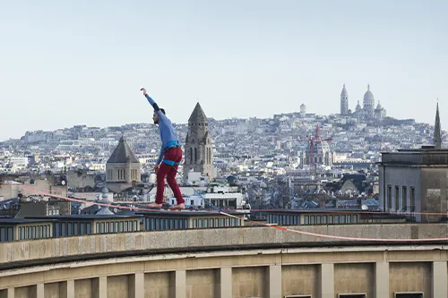Nathan Paulin, champion du monde de highline, pieds nus sur une sangle à 70 mètres de hauteur entre la Tour Eiffel et le Trocadéro pour le Téléthon.