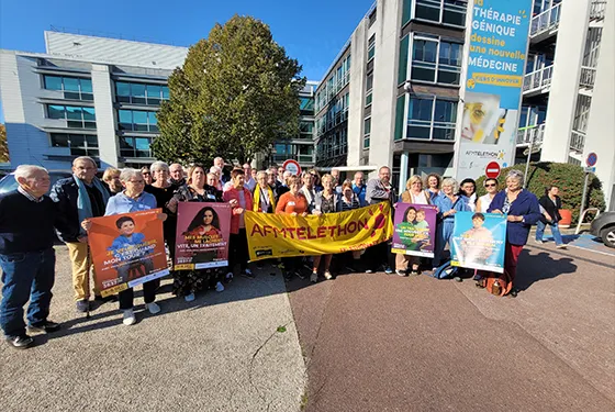 Visiteurs réunis devant Généthon, laboratoire de l’AFM-Téléthon dédié à la thérapie génique
