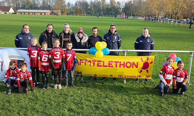 Un groupe de participants au Téléthon foot devant une banderole AFM-Téléthon