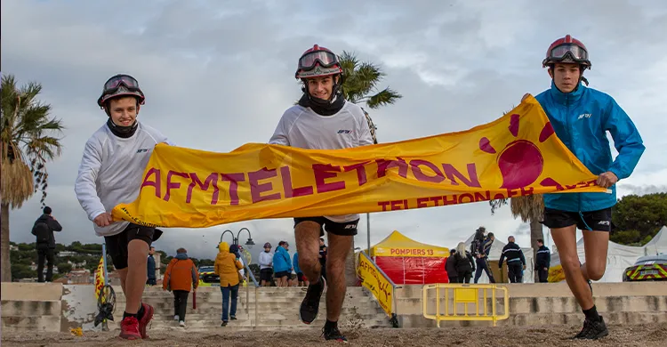 Des bénévoles tiennent une banderole sur la plage