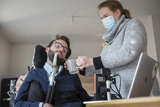 Une femme aidant une personne en situation de handicap à domicile