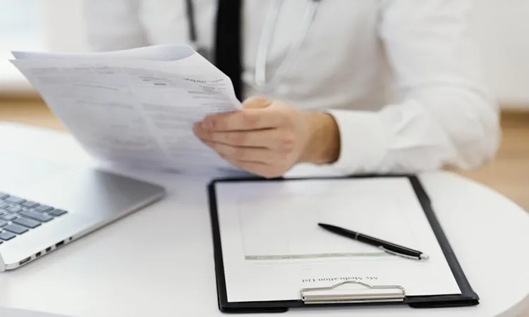 Vignette Actualité - Médecin avec une ordonnance dans les mains et dossier médical sur le bureau