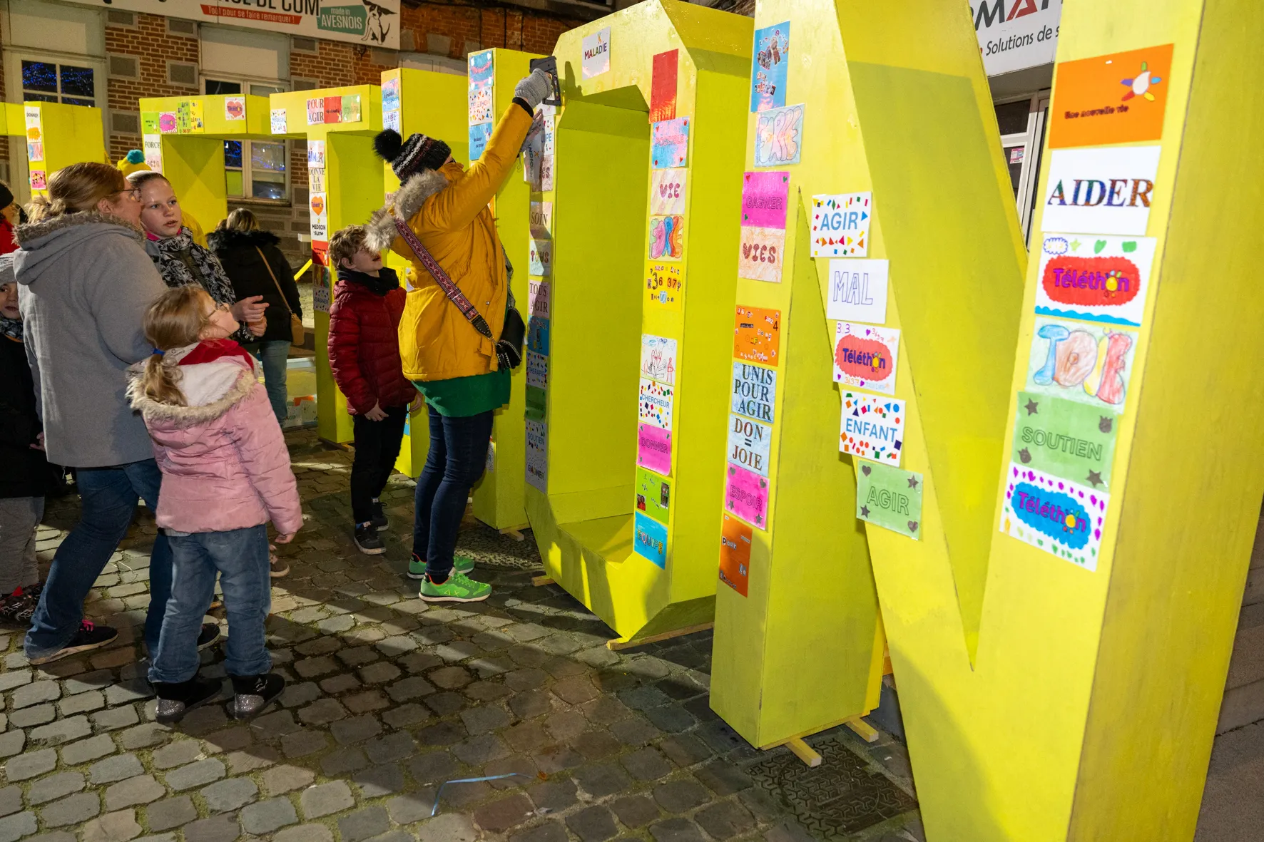 Petits et grands participent à la décoration des lettres symbolisant l'engagement d'Avesnes-sur-Helpe pour le Téléthon 2024