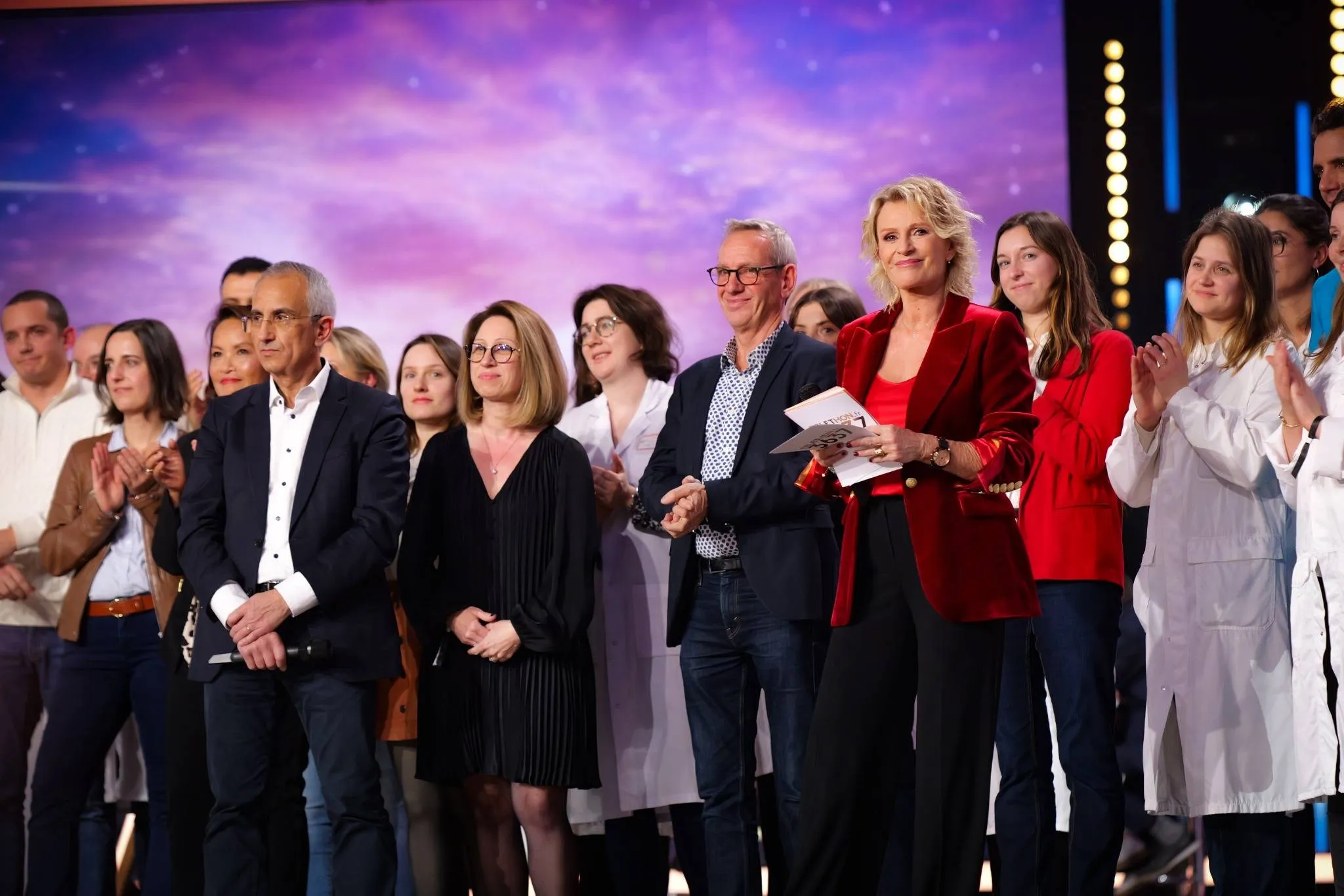 Serge Braun, directeur scientifique de l’AFM-Téléthon, entouré de soixante acteurs de la recherche engagés dans la lutte contre les maladies rares, sur le plateau du Téléthon 2024.