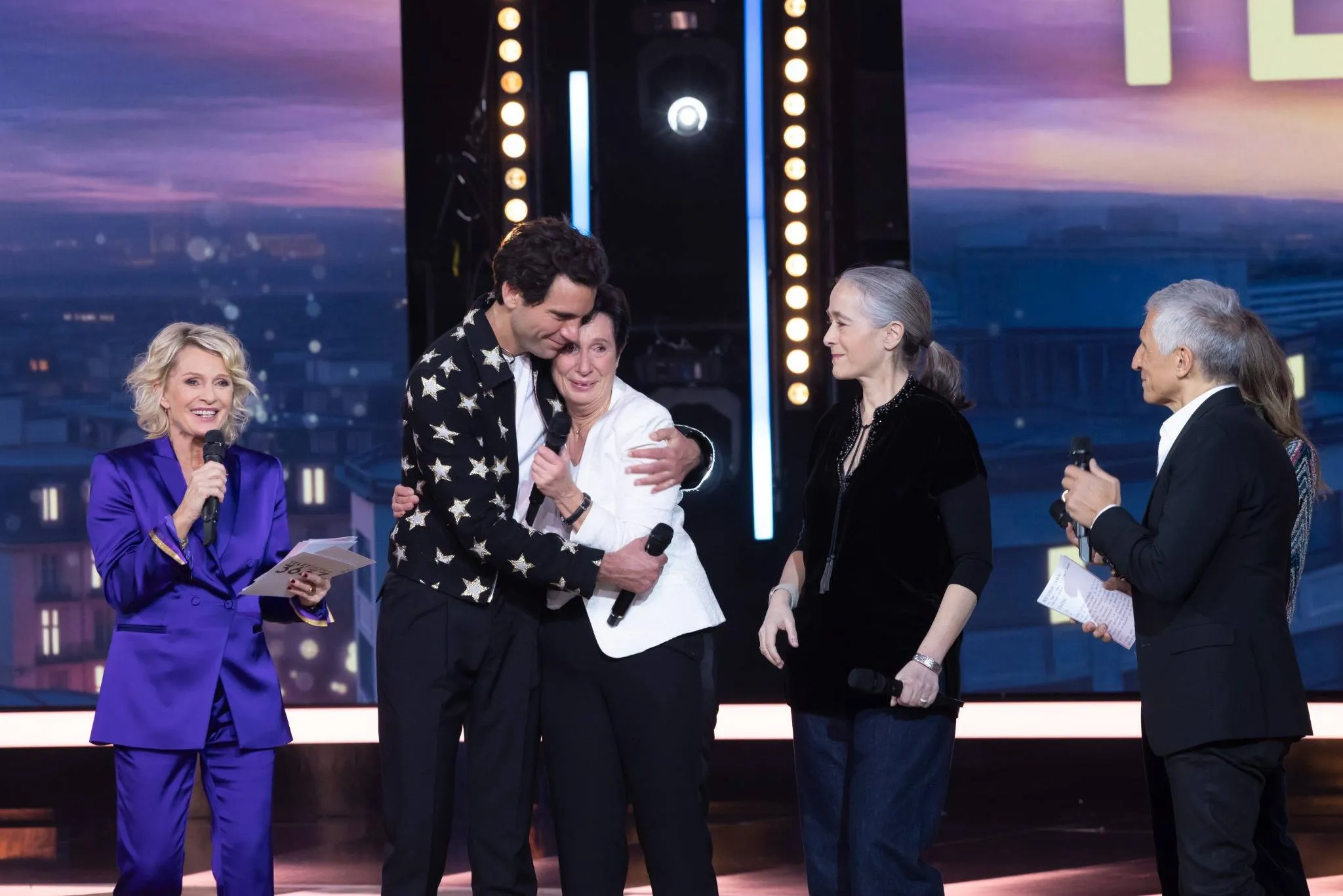 Laurence Tiennot-Herment, émue, partage un moment de tendresse avec Mika sur le plateau du Téléthon 2024. 