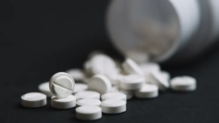 Vignette Actualité : Pilules blanches qui tombent d'une bouteille