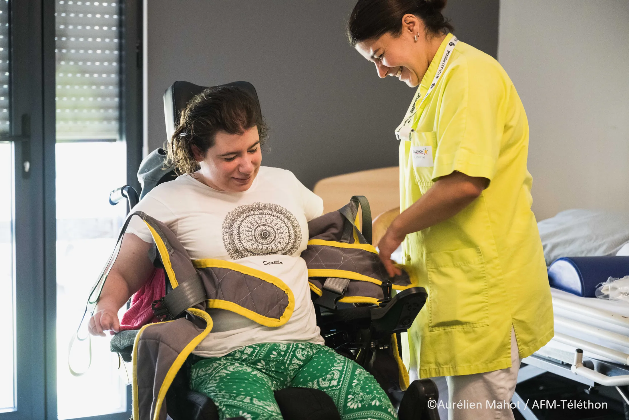 Photo d'une femme en fauteuil roulant avec son aide soignante au Village Répit Familles, La Salamandre