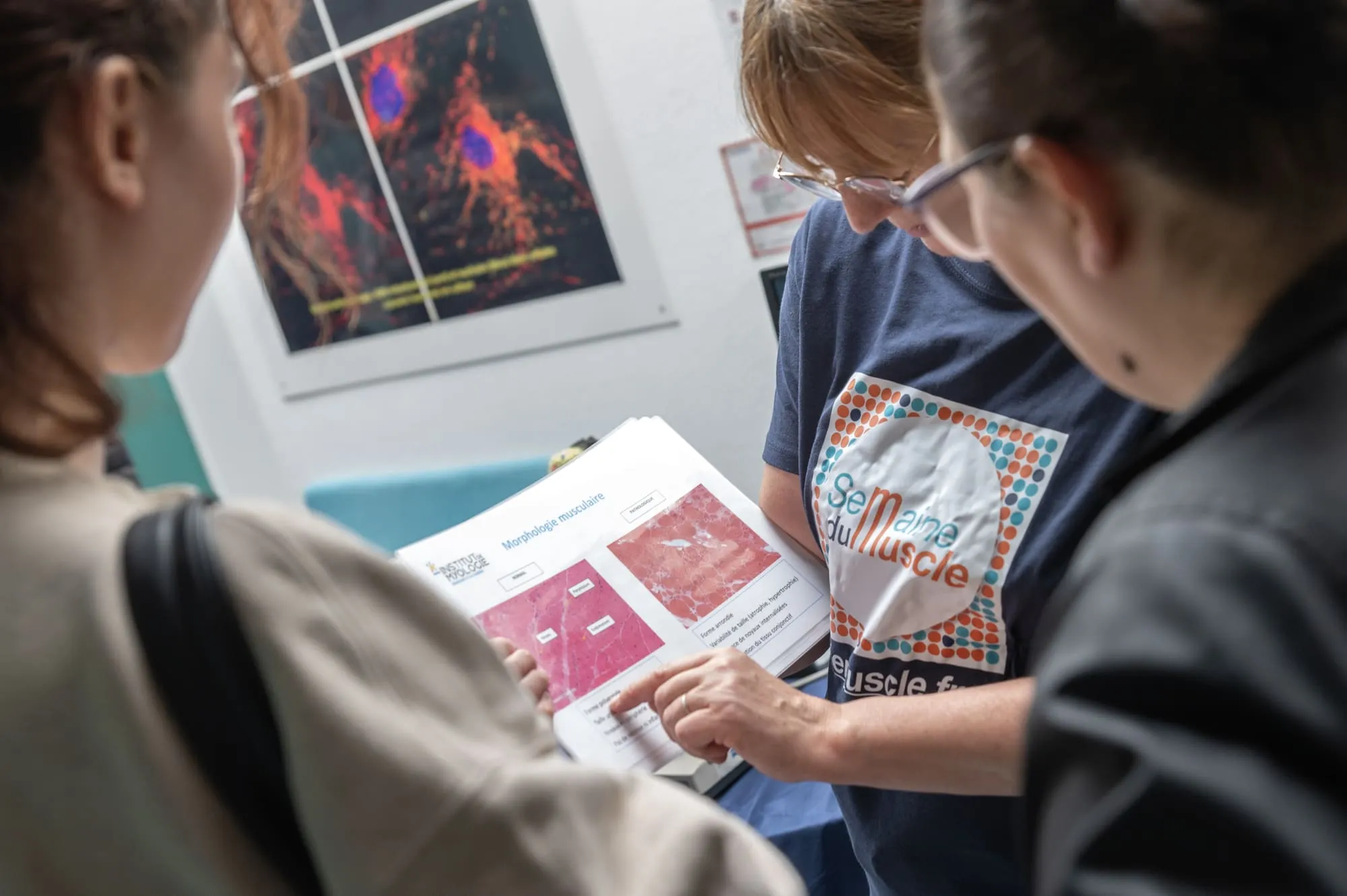 Une spécialiste de la myologie explique les différences entre muscle sain et muscle pathologique à partir de lames histologiques, dans un atelier pédagogique.