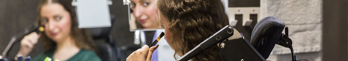 une jeune femme, équipée d'un support de bras, se maquille