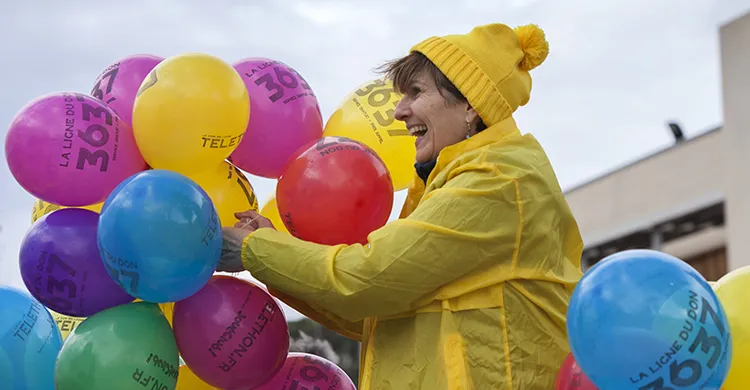 bénévole tenant des ballons